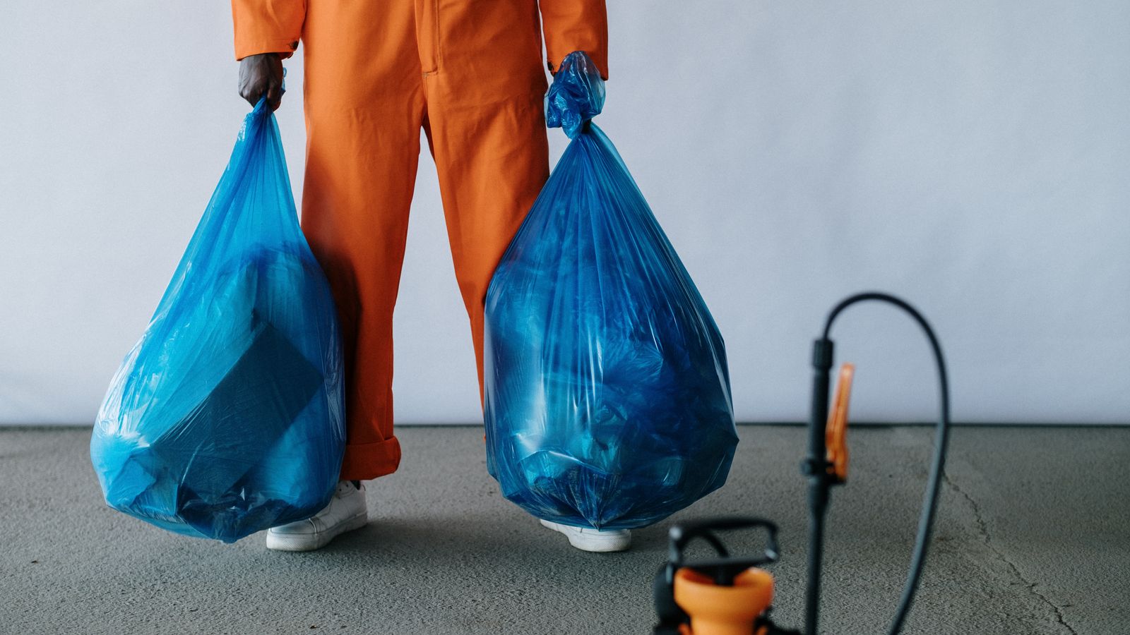 Tidy bagged trash set out at an apartment door for valet pickup